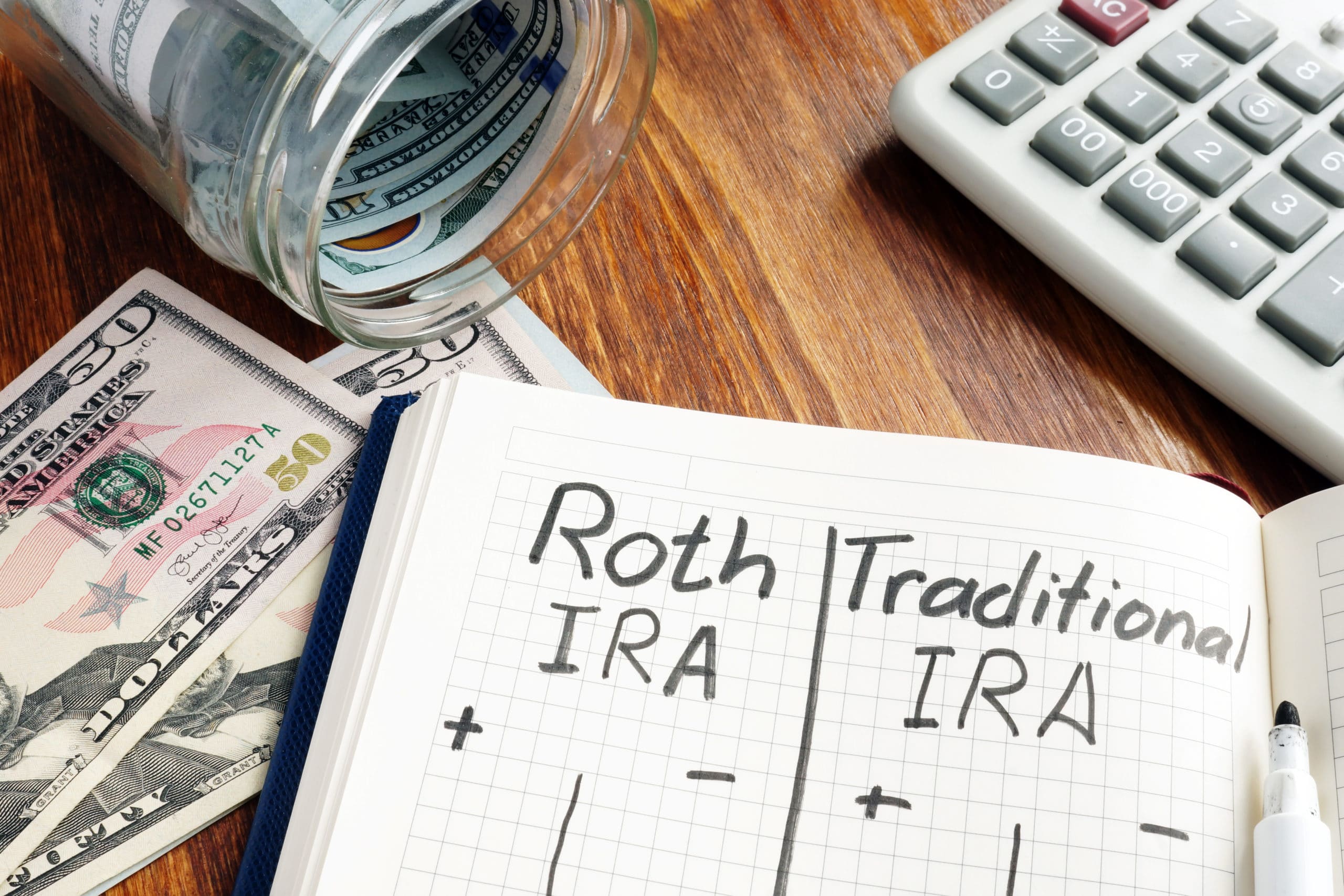 Image of desk with notebook saying Roth IRA or Traditional IRA