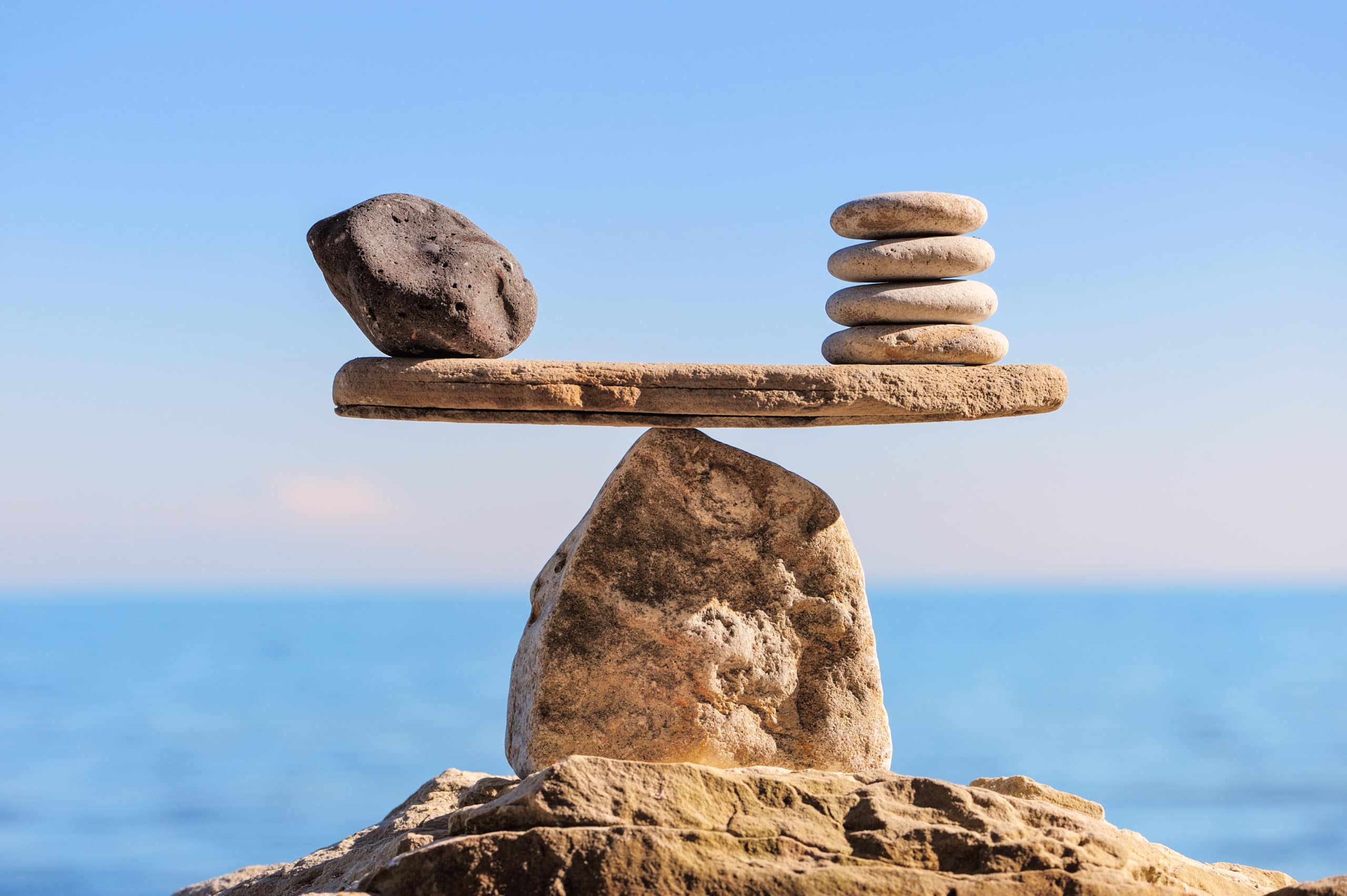 Picture of two stacks of rocks balancing on a flat rock on top of a bigger rock